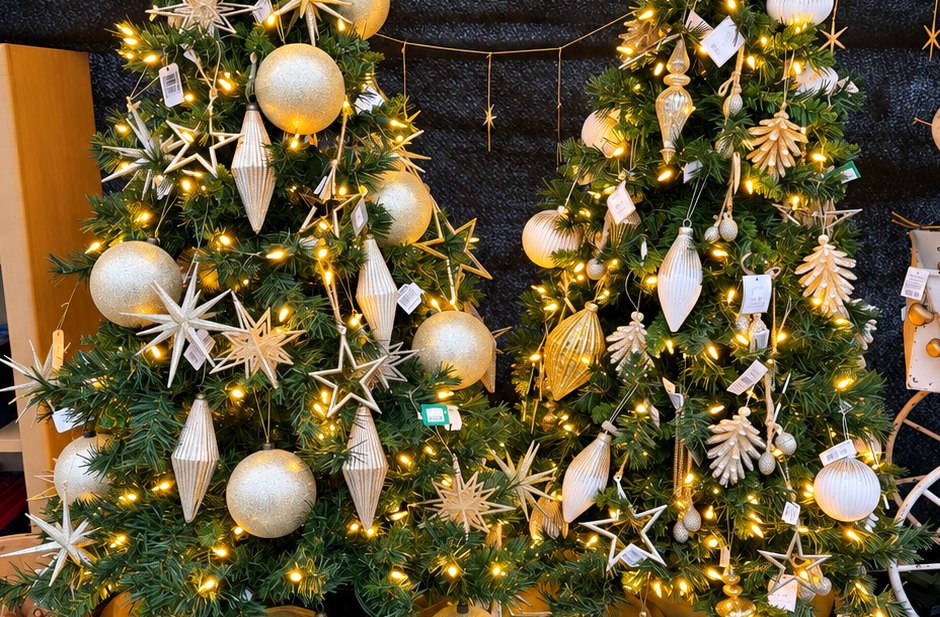 Holiday trees decorated with gold and silver ornaments and warm white lights
