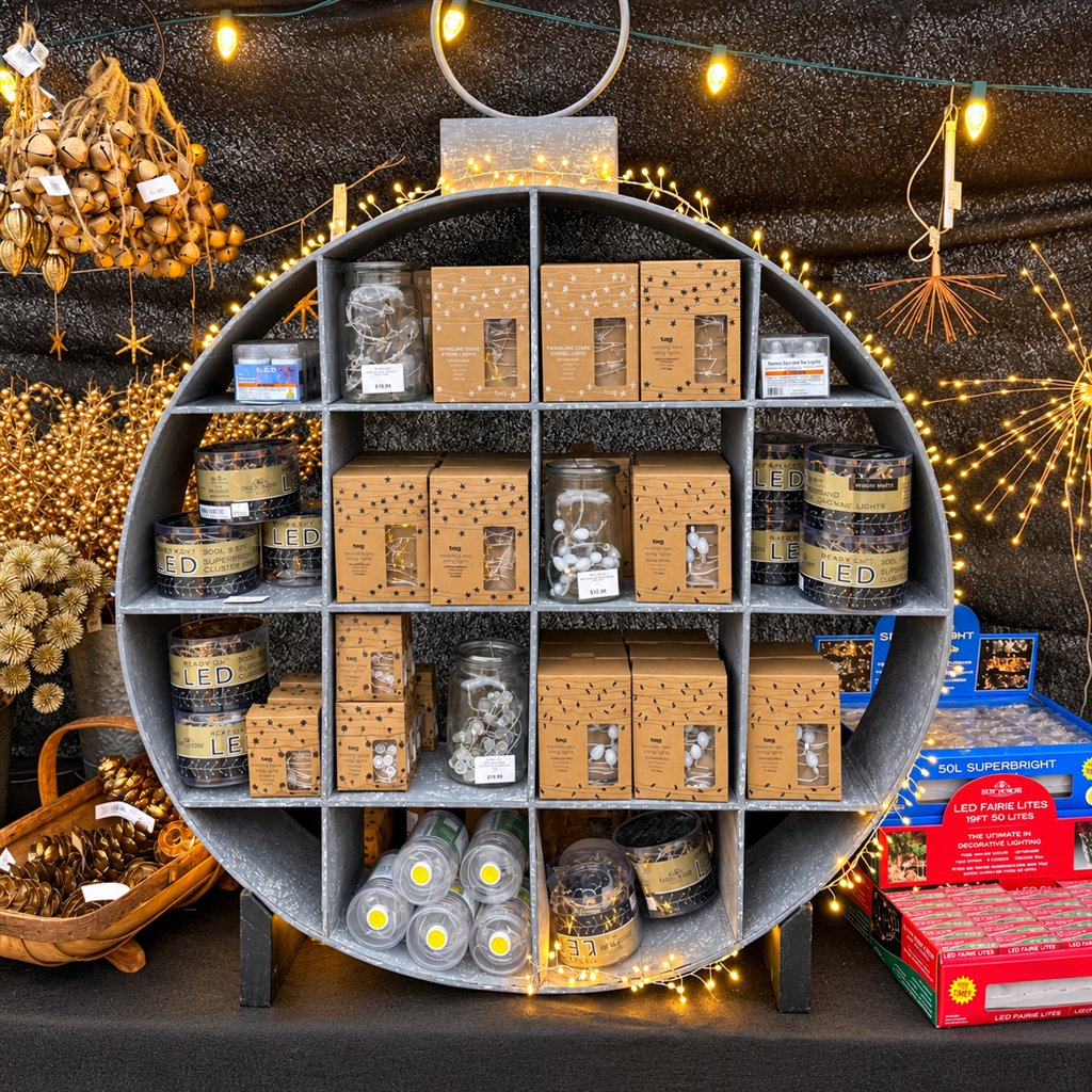 Warm white string lights and packaged holiday lighting on a round display shelf